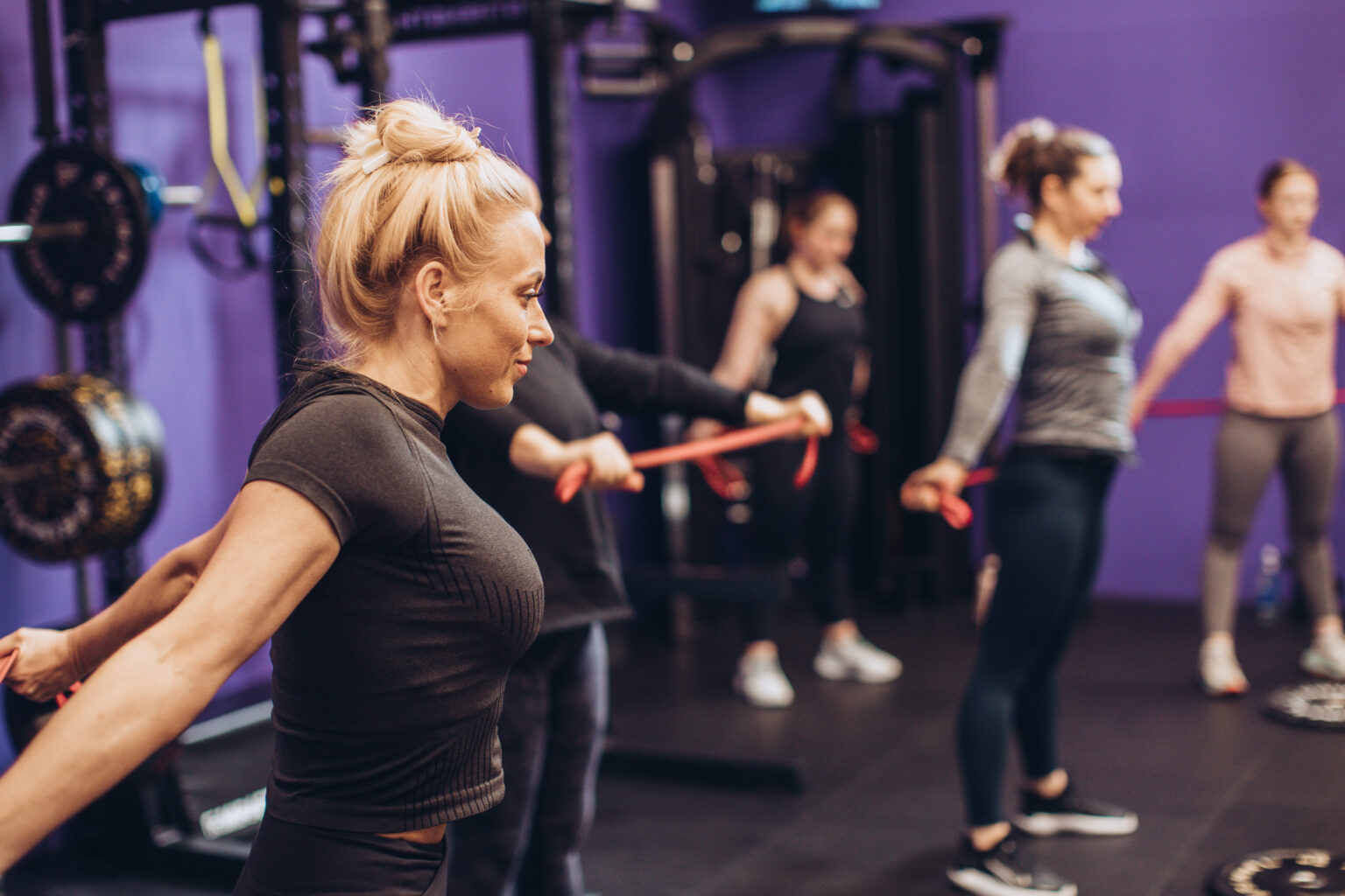 Members training with resistance bands in a coached group strength session
