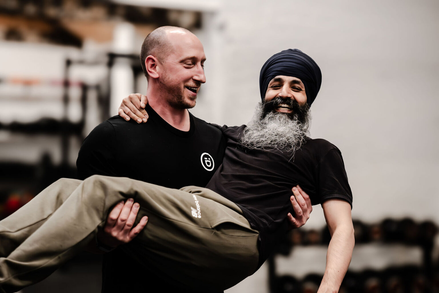 A coach and member sharing a laugh in the gym