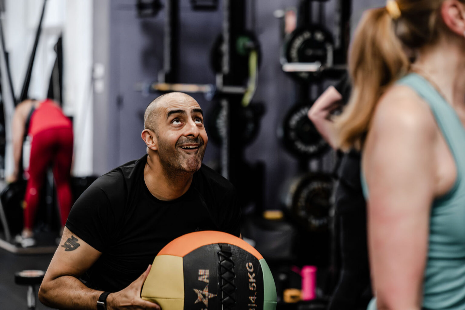 A member smiling with a medicine ball