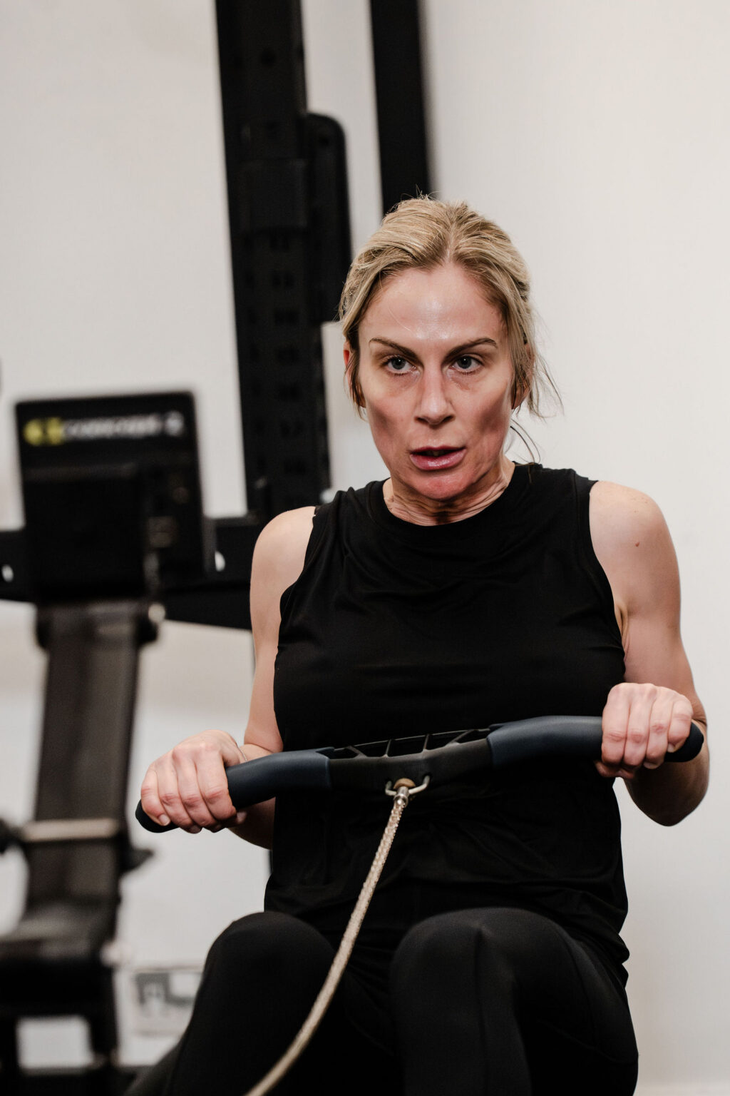 A member focused on the rowing machine during a group session