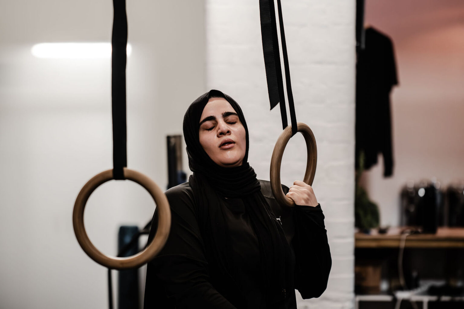 A member training on the gymnastic rings