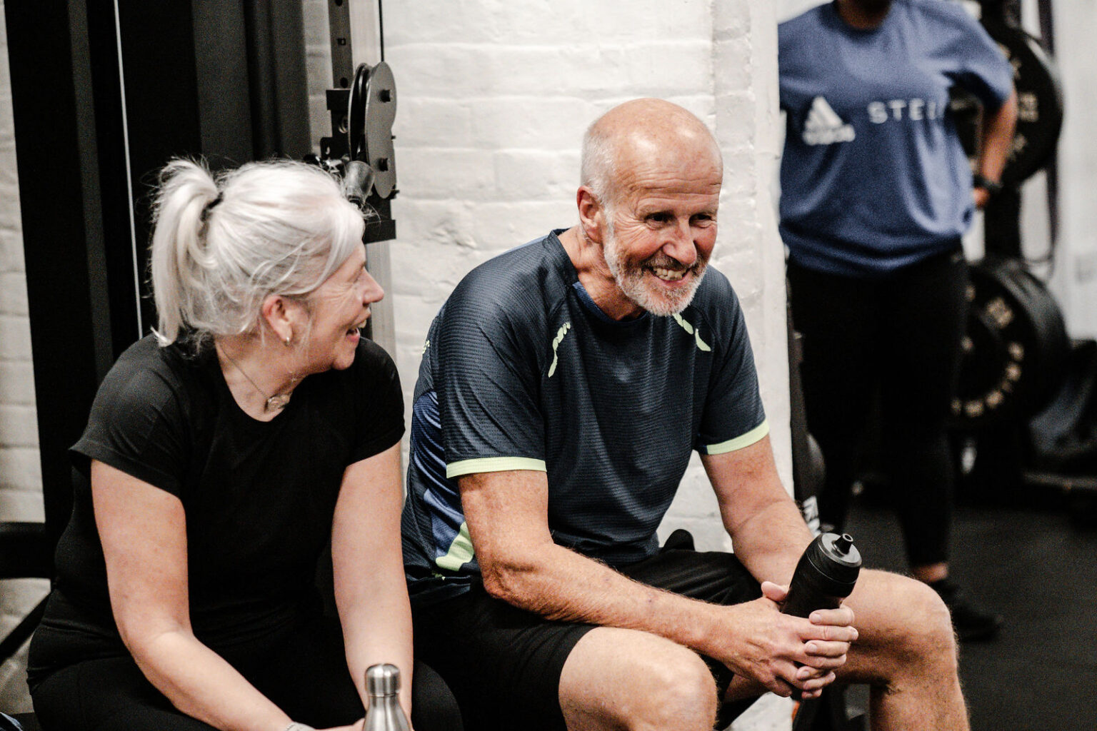 Two members smiling together between sets